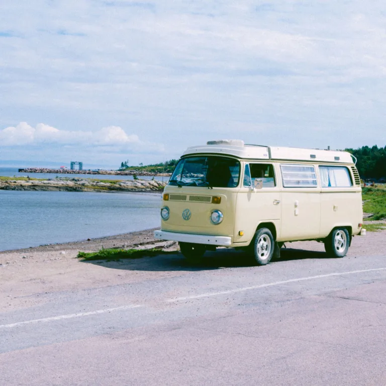 Cream VW T2 campervan parked by the sea