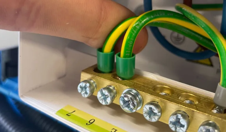 Green and yellow earth conductors being fitted into a brass earth bar