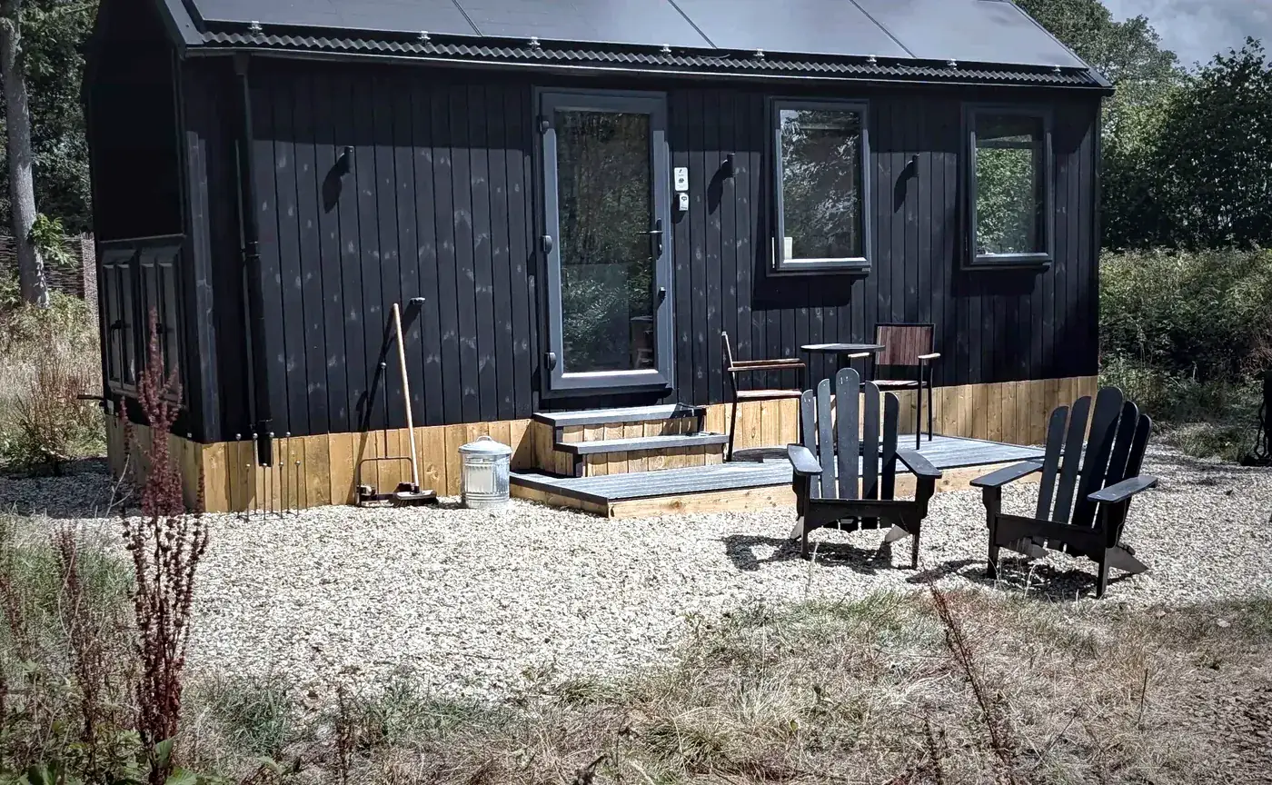 Timber guest cabin with solar panels across the roof